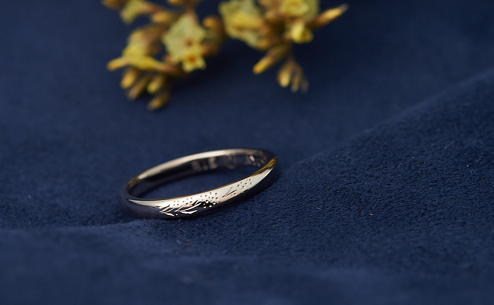 かすみ草の彫りとうさぎのシルエットが入った捻りのK18WG結婚指輪