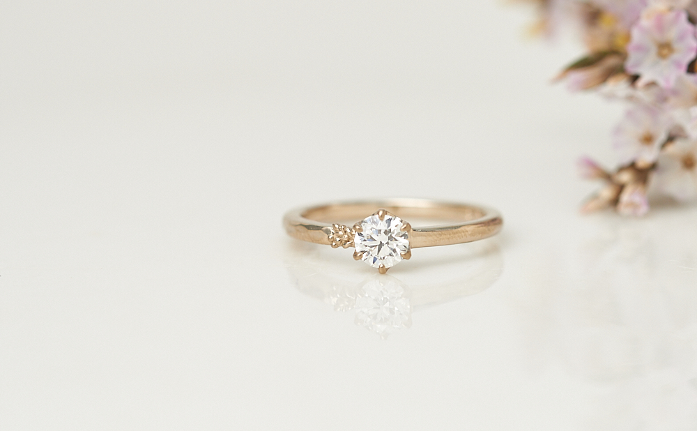 草花の装飾とテクスチャーが入ったアシンメトリーのダイヤモンドK18CG婚約指輪