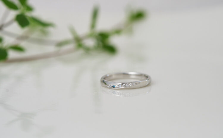 ブルーダイヤモンドがキラリ輝くひねり留めの婚約指輪